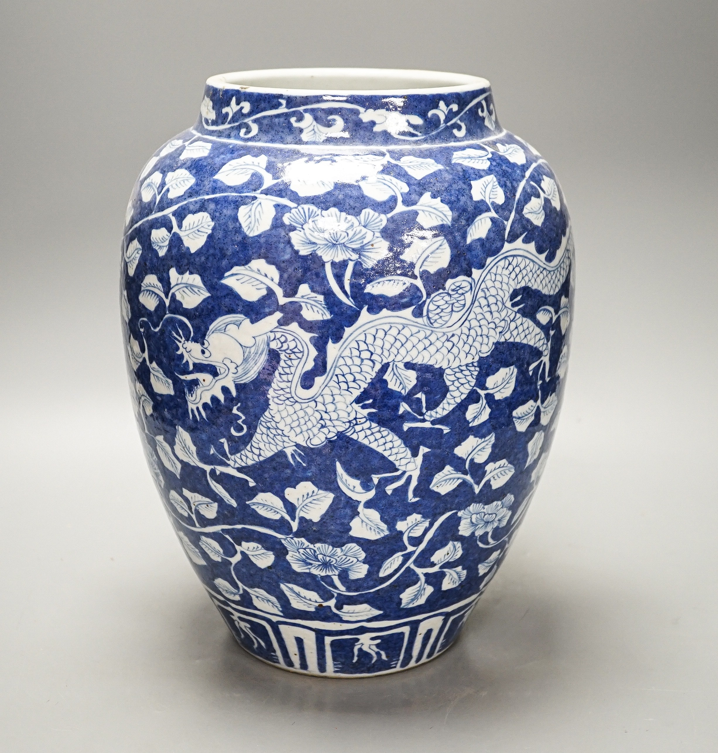 A Chinese blue and white ovoid jar, 19th/20th century, painted with dragons amid flowers and foliage, 33 cms high.